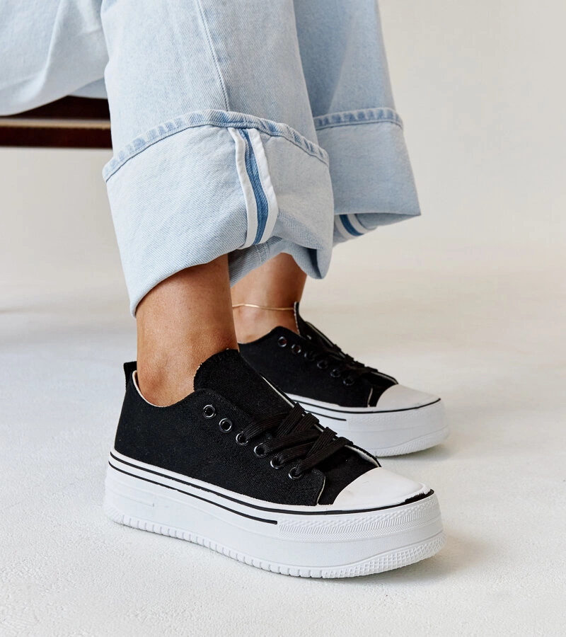 Bahirának vastag talpú fekete tornacipői