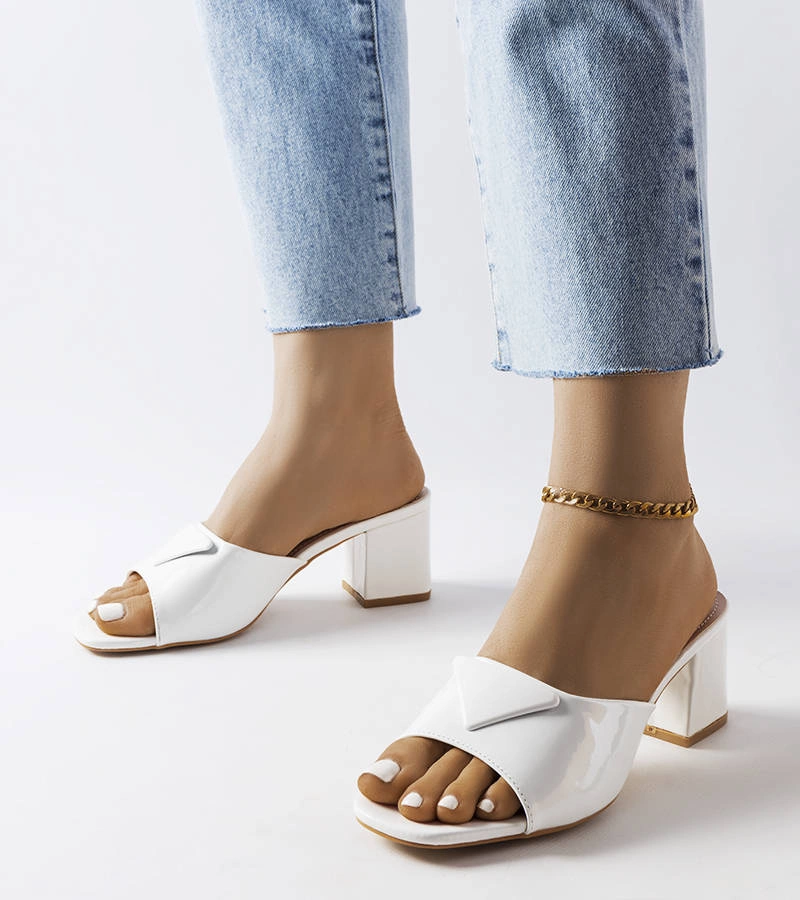 Fehér lakkozott ágakon található papucs