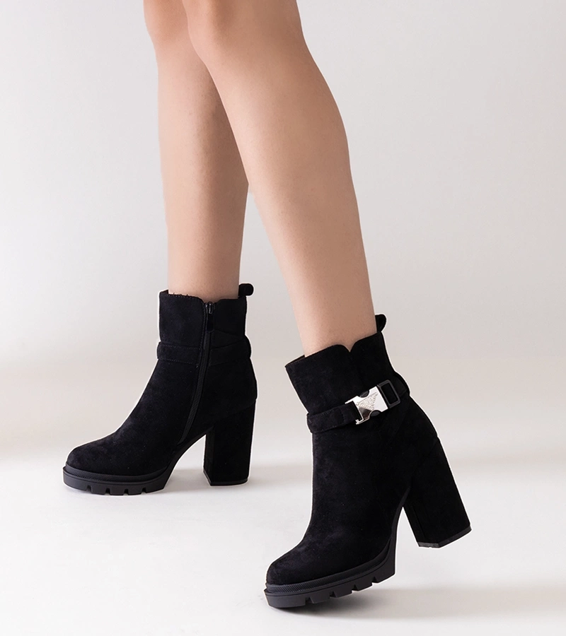 Fekete, tűsarkú csizmák Torhia csattal díszítve.