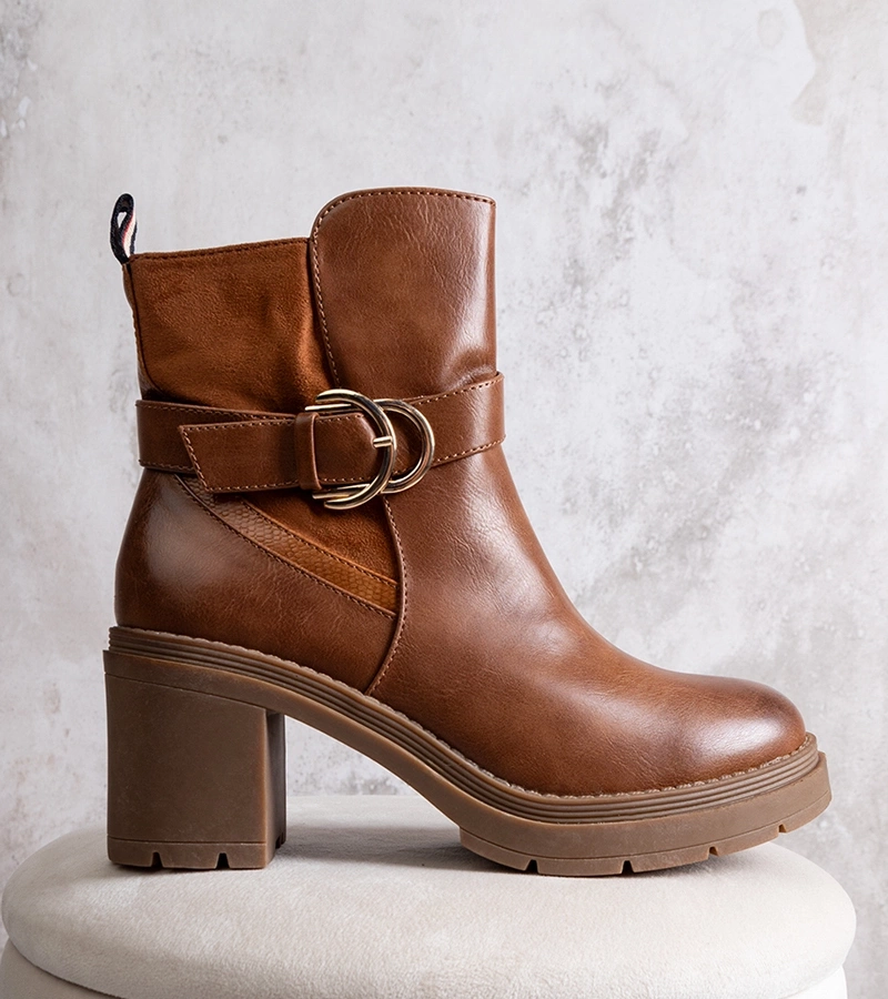 Brązowe botki na słupku Mirka po węgiersku to: "Mirka barna, sarokkal ellátott csizma".