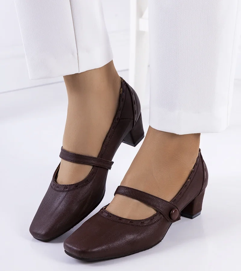 Barna szíjjal díszített cipők