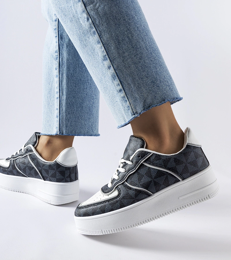 Fekete monogrammal díszített tornacipők.